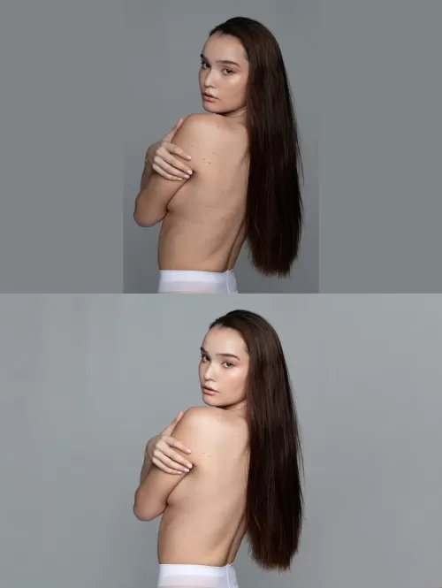 Молодая женщина с длинными темными волосами и обнаженной спиной смотрит через плечо на сером фоне